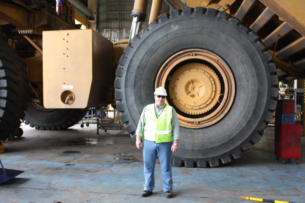 Dennis Hickman beside a Caterpillar 797B mining truck at Goonyella Riverside mine, Queensland